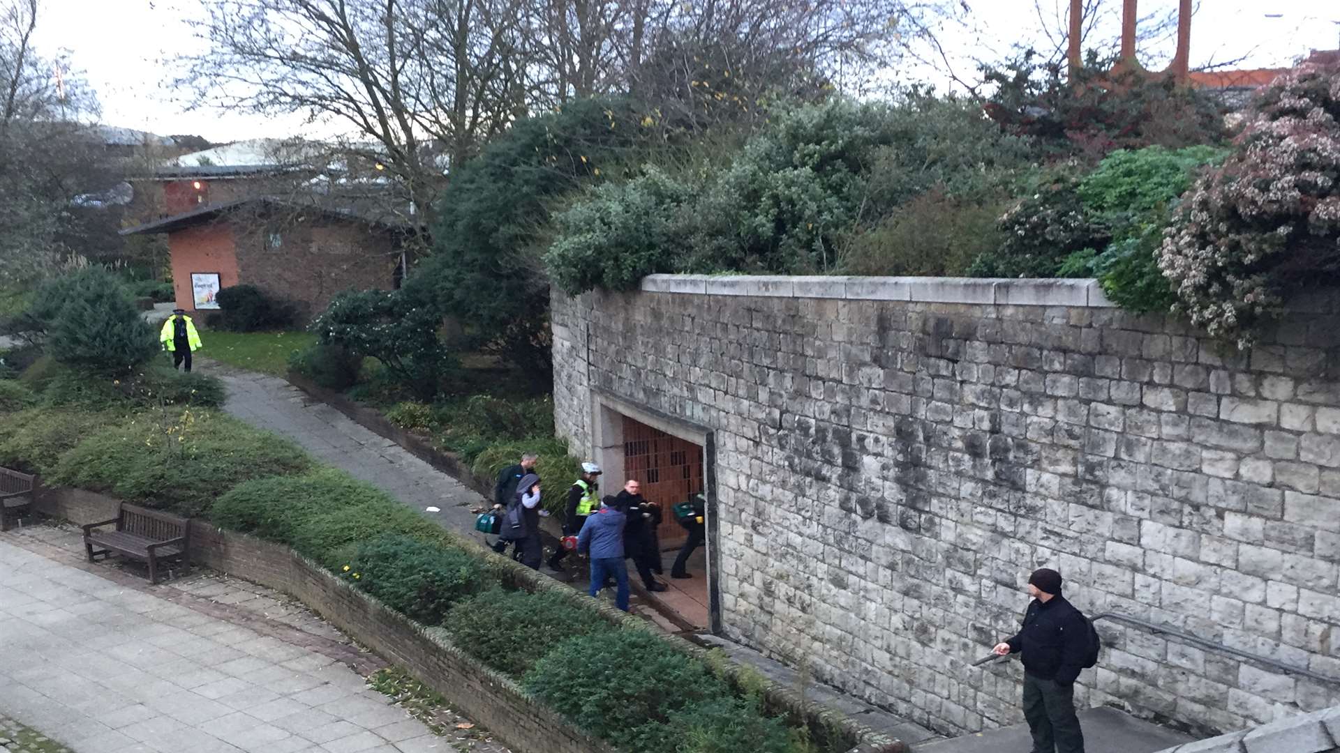 Paramedics move man through the underpass towards High Street.