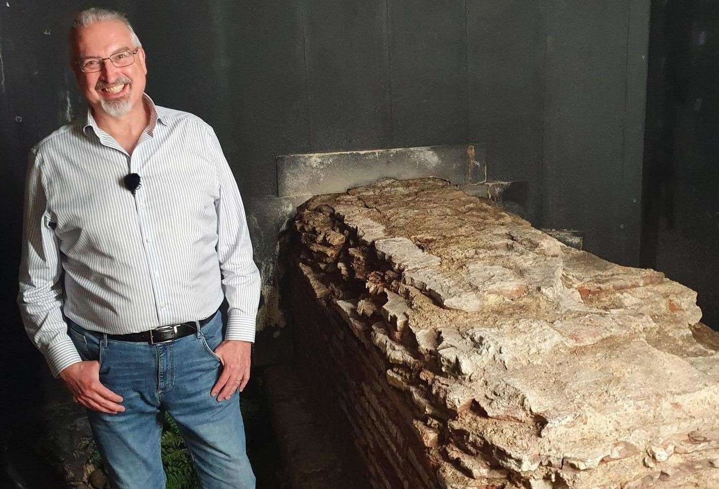 Presenter Dr Simon Elliott examines the remains of the Roman basilica law courts in London beneath a barbers in Leadenhall Market