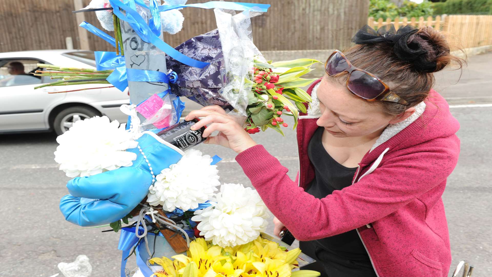 Thomas Rossiter's wife, Genty Bignall, leaving a can of Jack Daniels in a boxing glove as a tribute in Lynden Way, Swanley