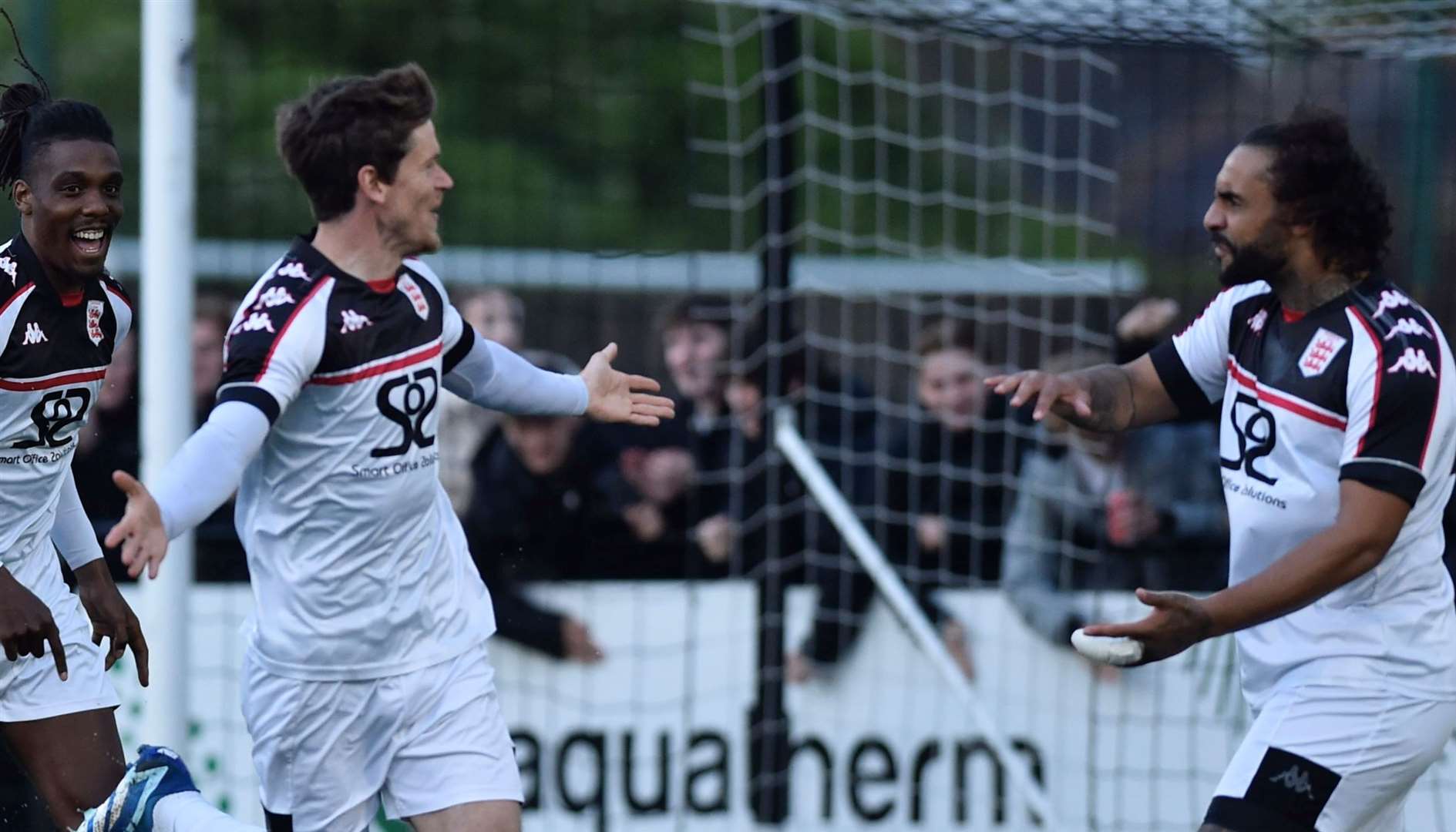 Faversham's opening scorer Billy Bingham celebrates with strikers Stefan Payne and Daniel Thompson - but the Lilywhites let a first-half lead slip in the 2-2 play-off semi-final draw before losing on penalties. Picture: Ian Scammell