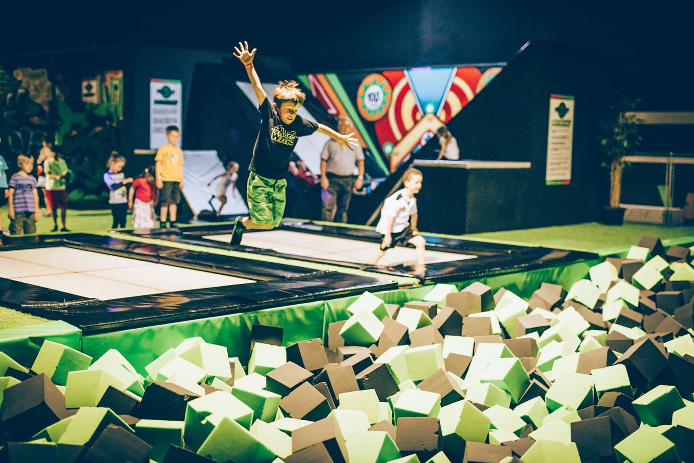 Children jump into a Flip Out foam pit