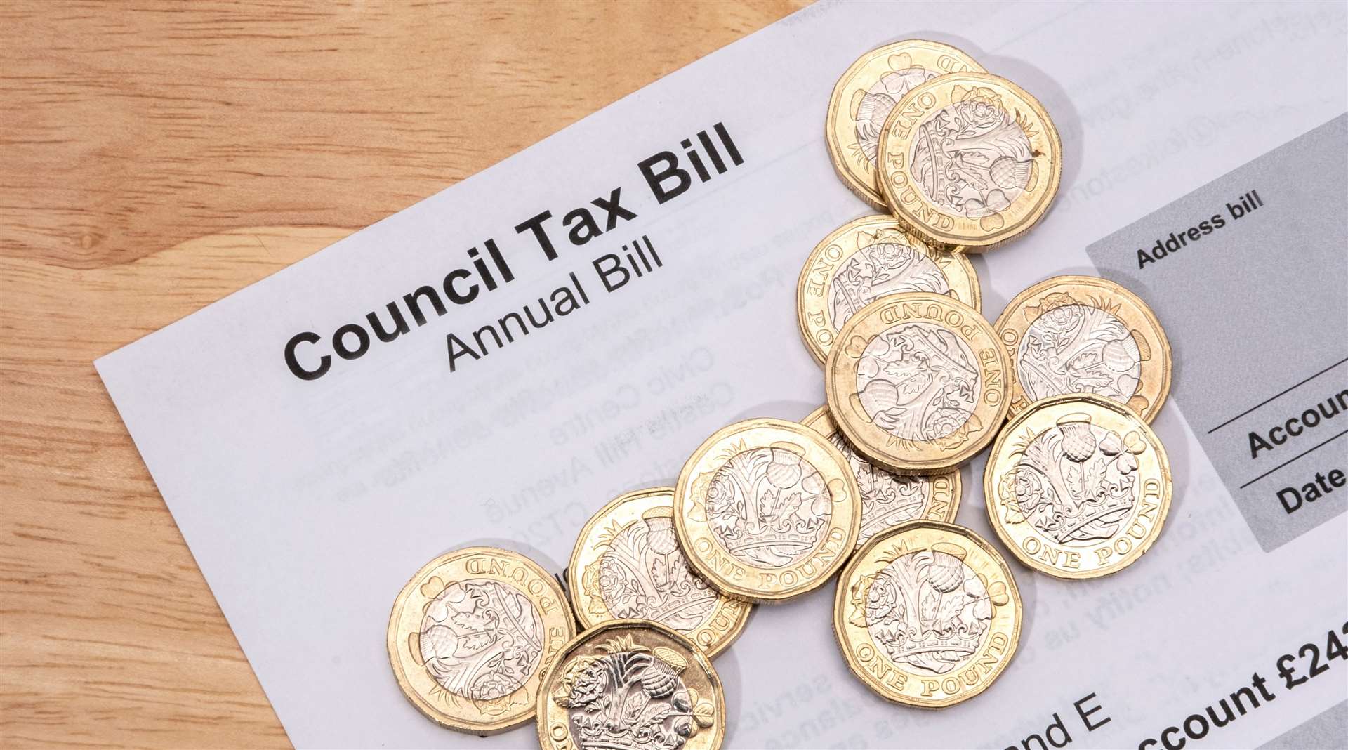 UK one pound coins placed on a Council Tax Bill