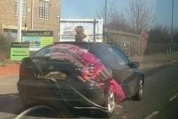 A child with her head through the sunroof of a car. Picture: @LulabellLucy