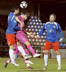 Ashley Miller goes up for a header for Gillingham against Welling