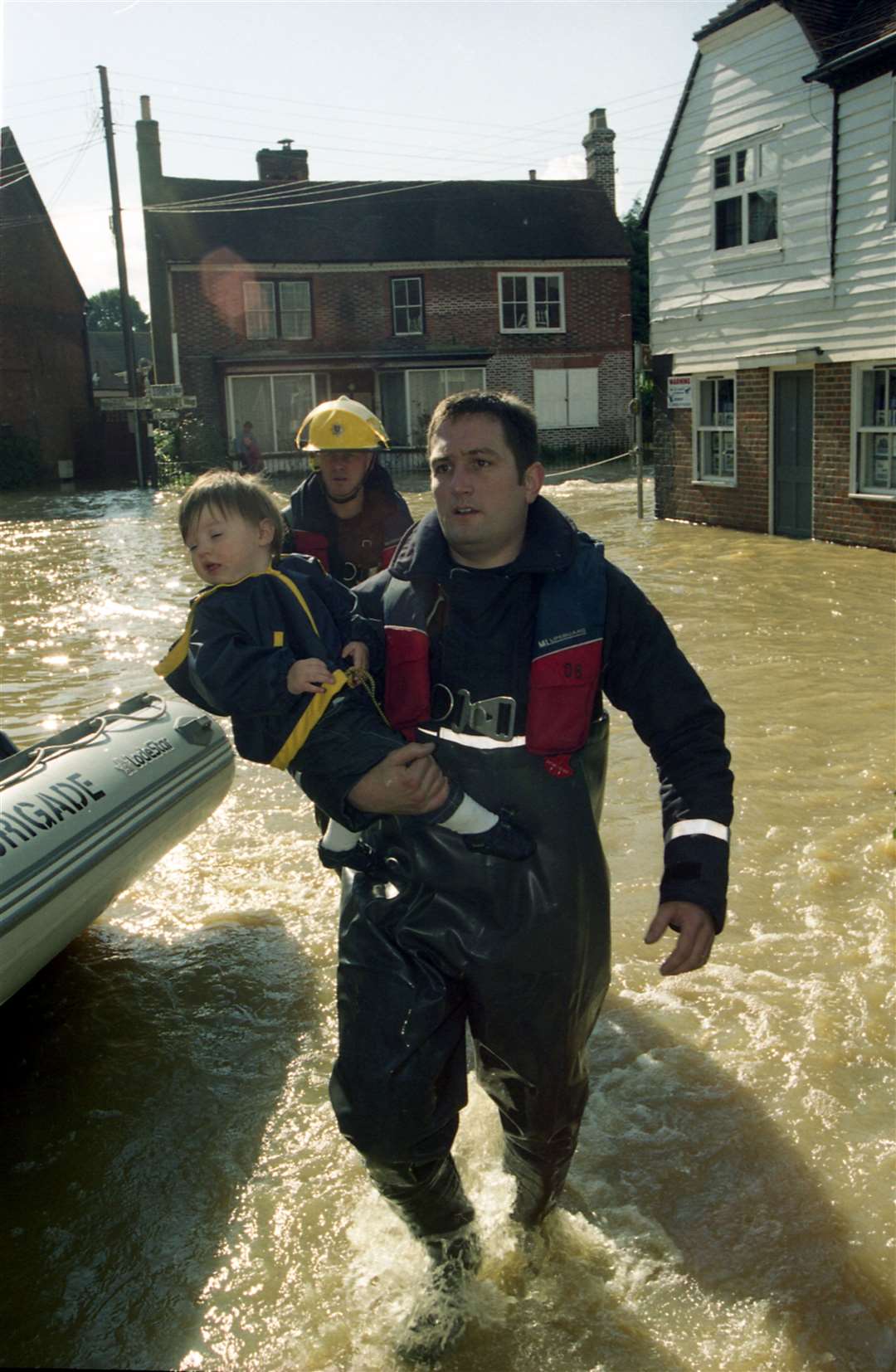 A young child being taken to safety away from the water in Hampstead Lane, Yalding