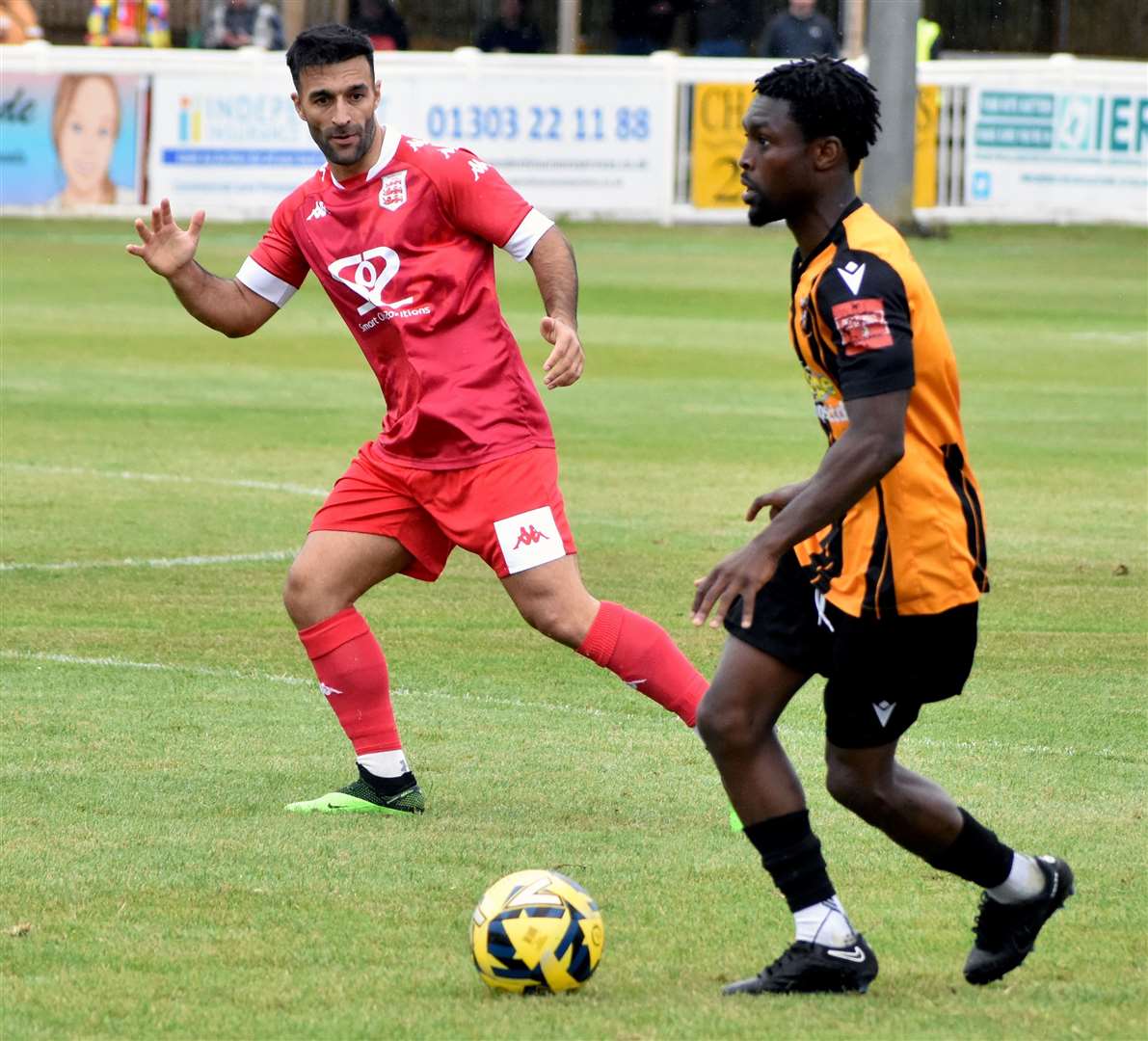 Folkestone midfielder Ade Cole turns away from Faversham player Kieron McCann. Picture: Randolph File