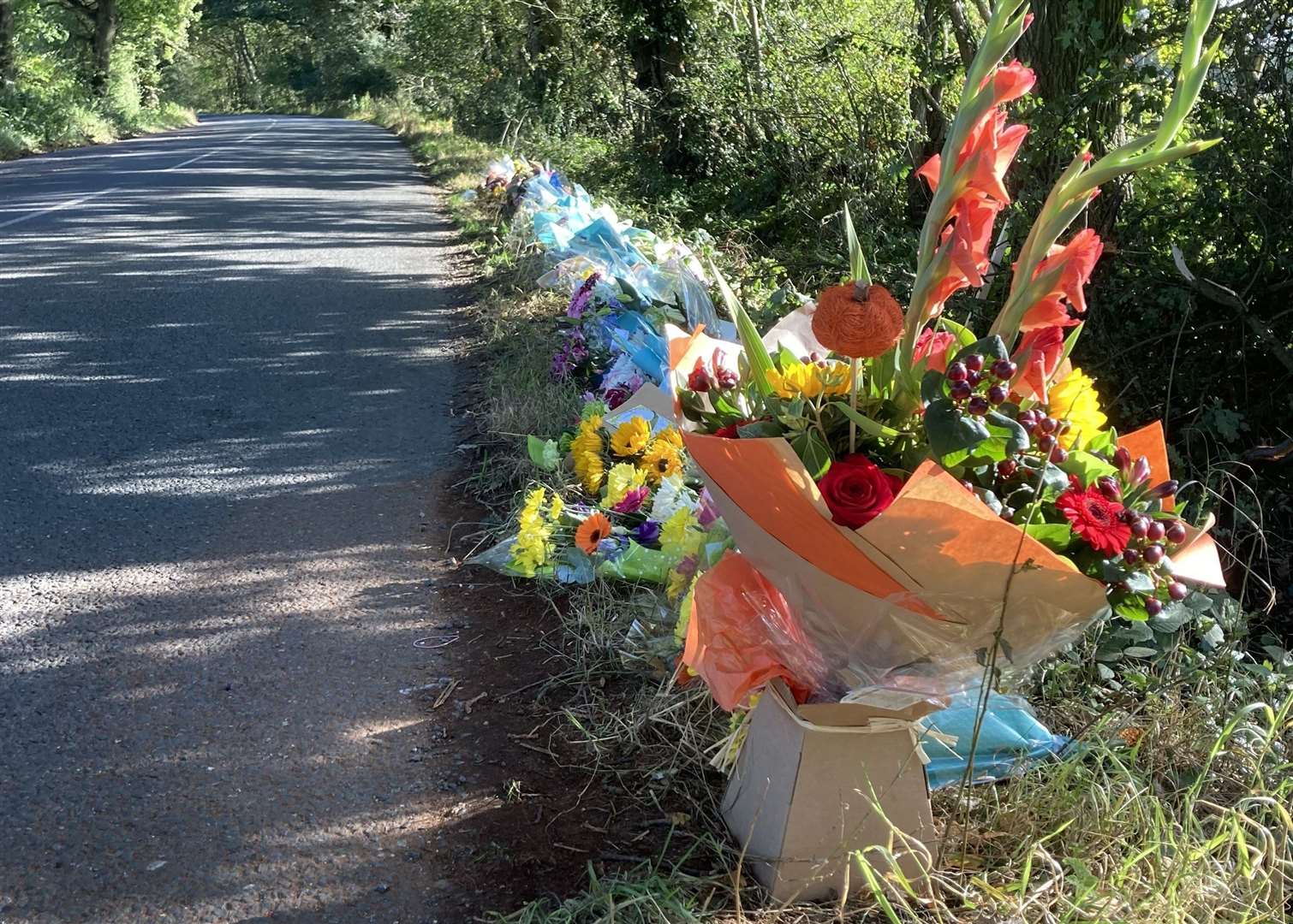 Floral tributes line Lenham Road, the scene of a crash which claimed four lives on Sunday, October 10