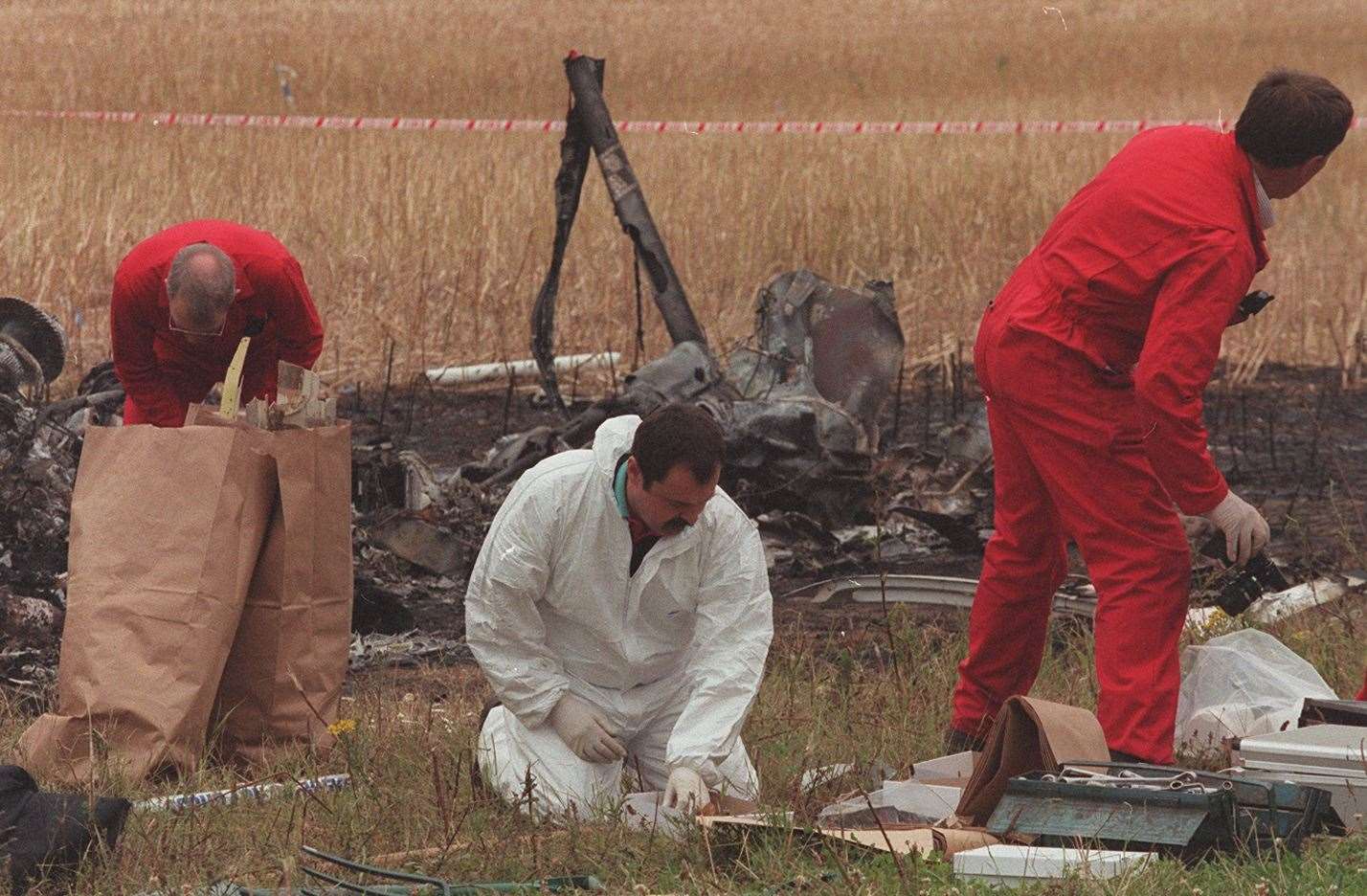 Forensic officers scour the scene of the deadly crash