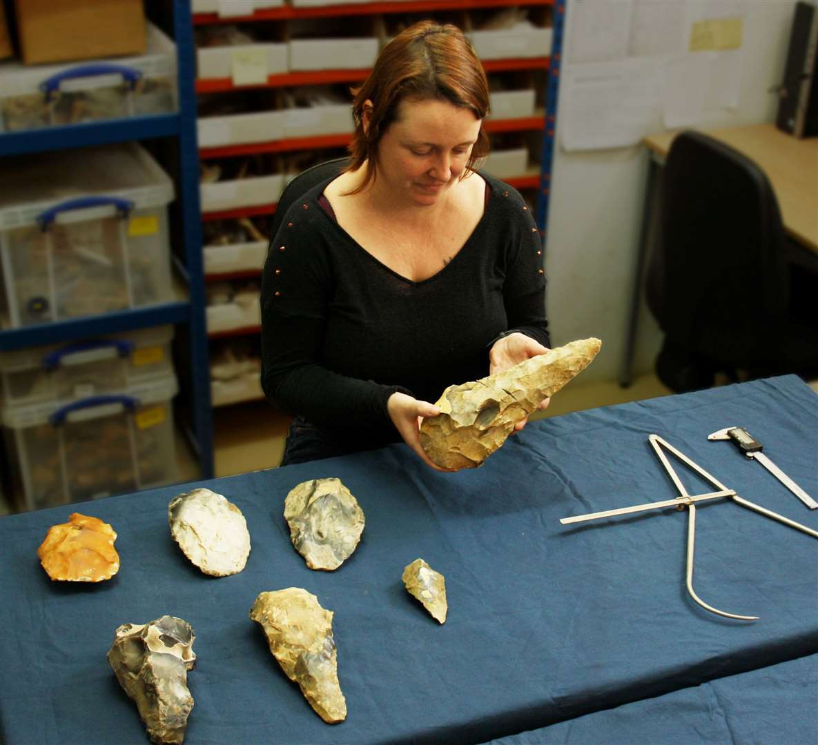 Senior archaeologist Letty Ingrey measures the largest giant handaxe: Archaeology South-East/ UCL