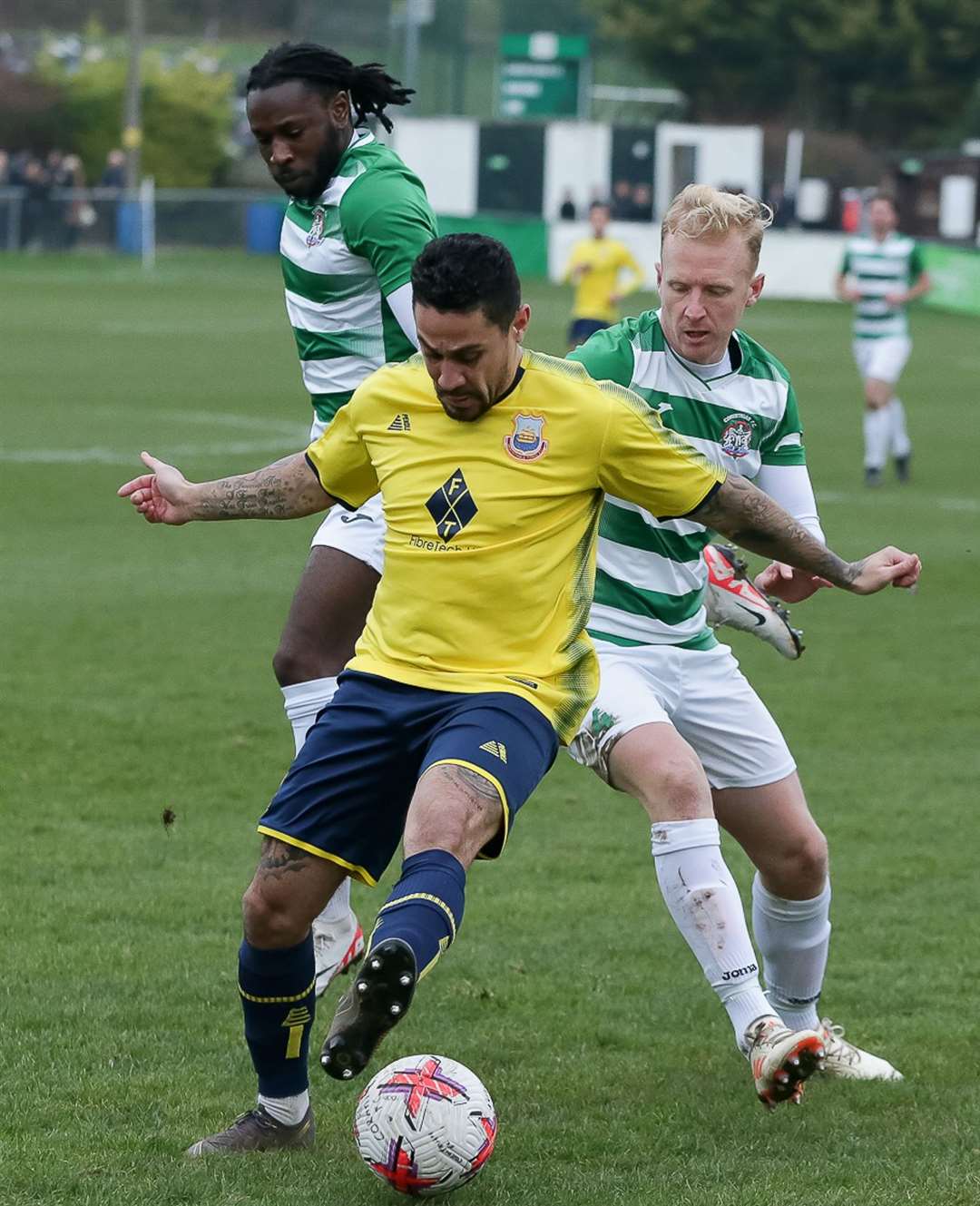 Whitstable winger Harrison Carnegie fights off two home players. Picture: Les Biggs