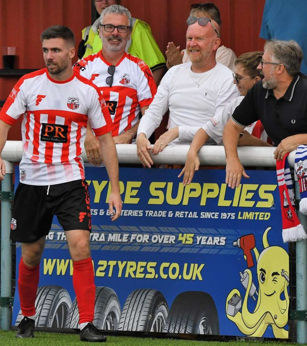 Andy Gray (middle white shirt) celebrates with Sheppey goal scorer Danny Leonard. Pic: Mark Richards