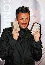 Peter Andre signing bottles of his new perfume.