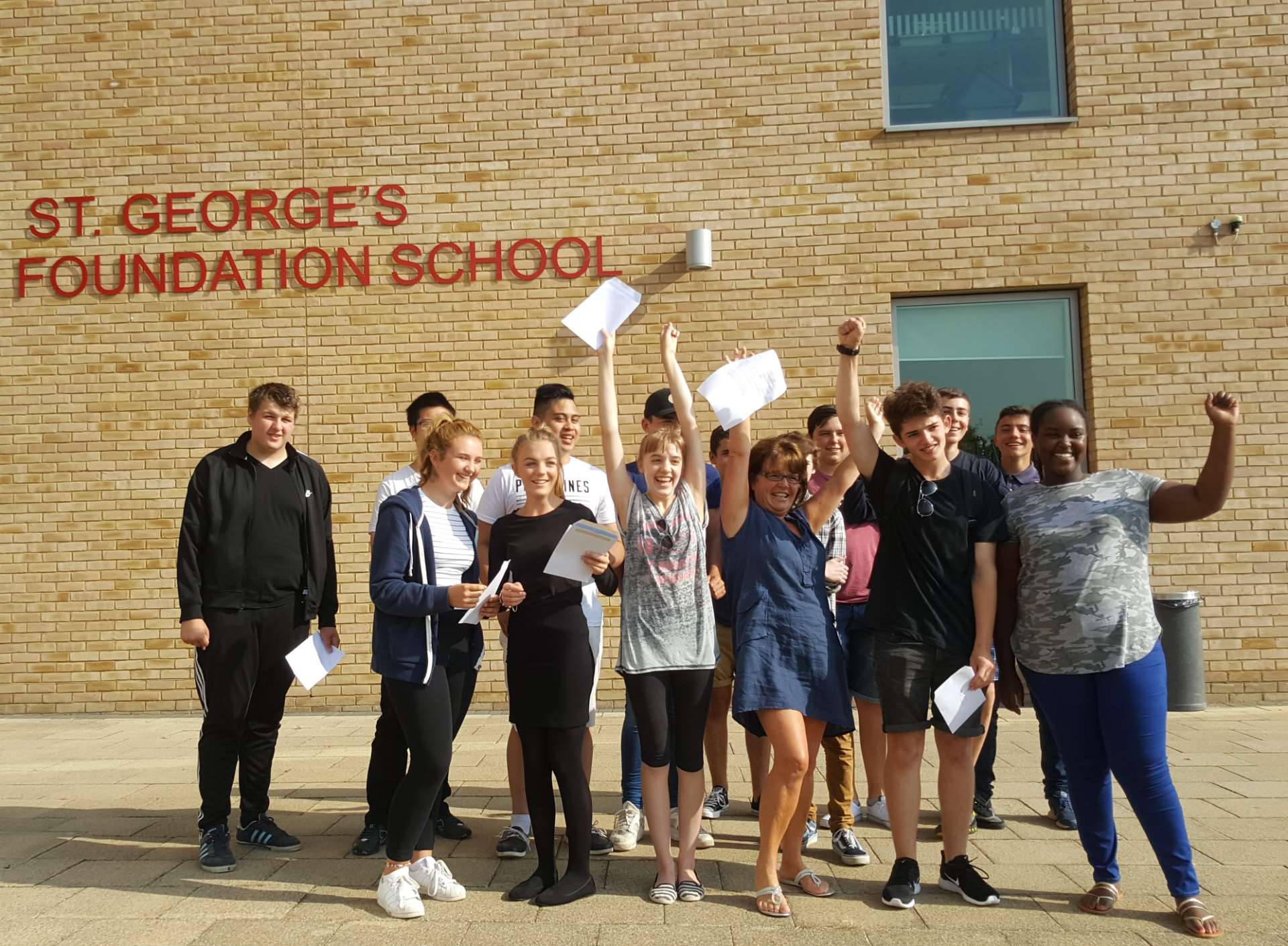 Pupils at St George's Foundation School celebrate with head teacher Kim Stoner