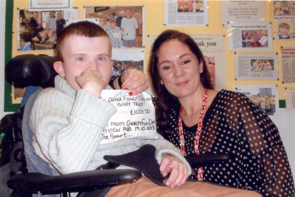 Joseph Peaurt presenting the money raised at the fun day to Lindsey Wileman, fundraising officer at the Oliver Fisher Special Care Baby Unit