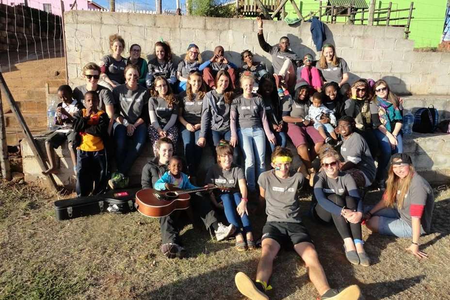 Abi Nelson - with the blue hat in the back row - with young beneficiaries and fellow volunteers