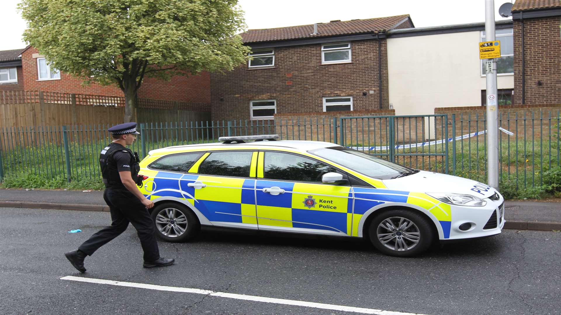 A police officer walks outside a police cordoned off area outside a flat in the alley way near Kinross Close in Princes Park after Mr Berry's body was found