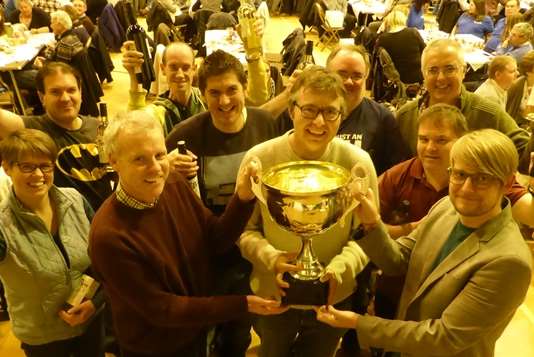 Stargating across the Quizziverse are presented with the KM Big Charity Quiz trophy by sponsors David Fifield of Hallett and Co and Jamie Wynn of Specsavers