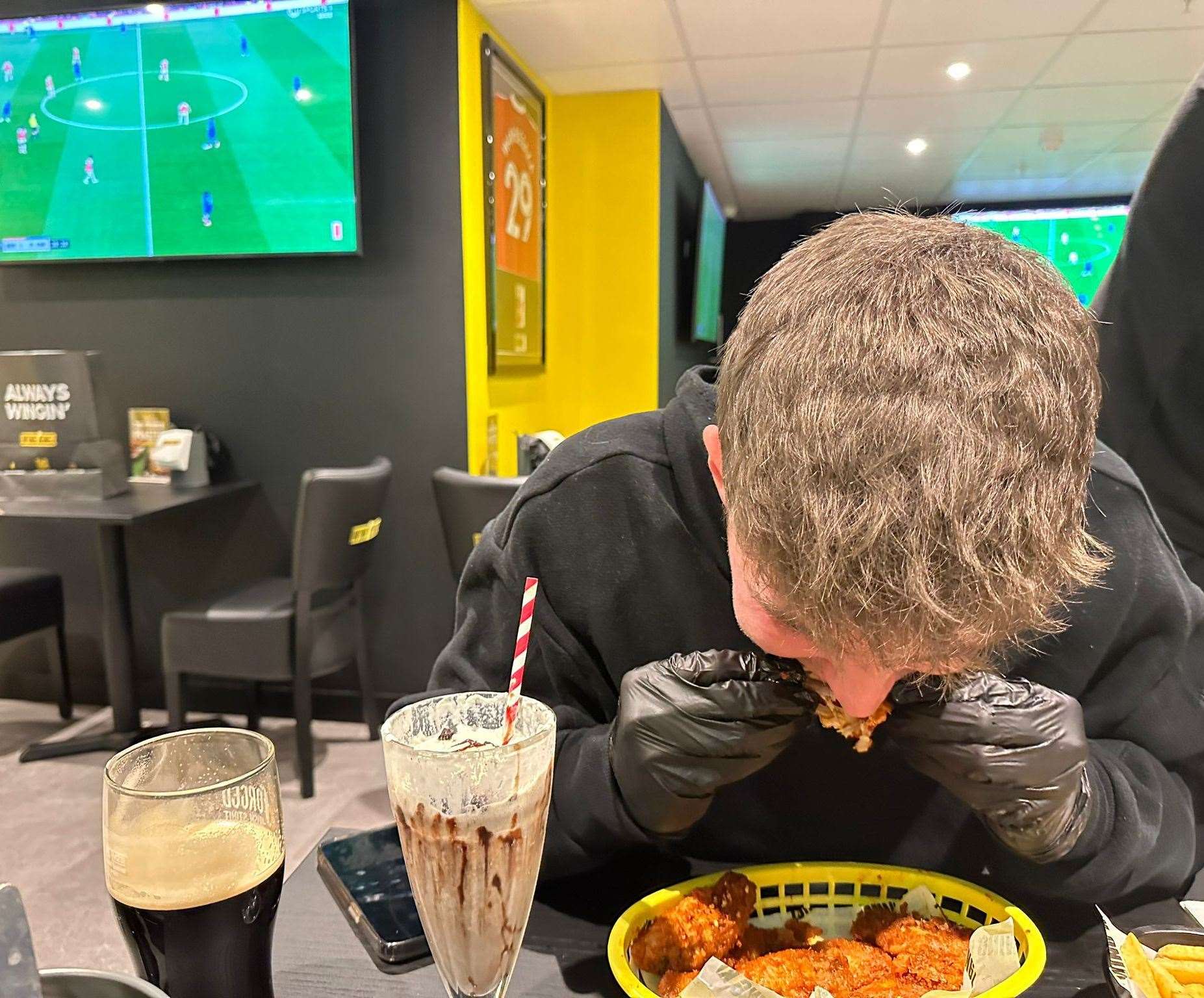 Reporter Ollie Leonard takes a bite out of an extremely hot chicken wing