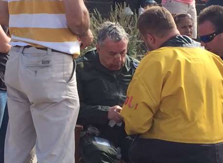 Rescuers attend to the pilot. Picture: Bruno Tilley