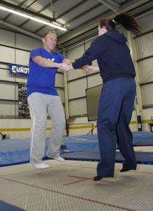 Kat Driscoll shows Alex Hoad how to trampoline.