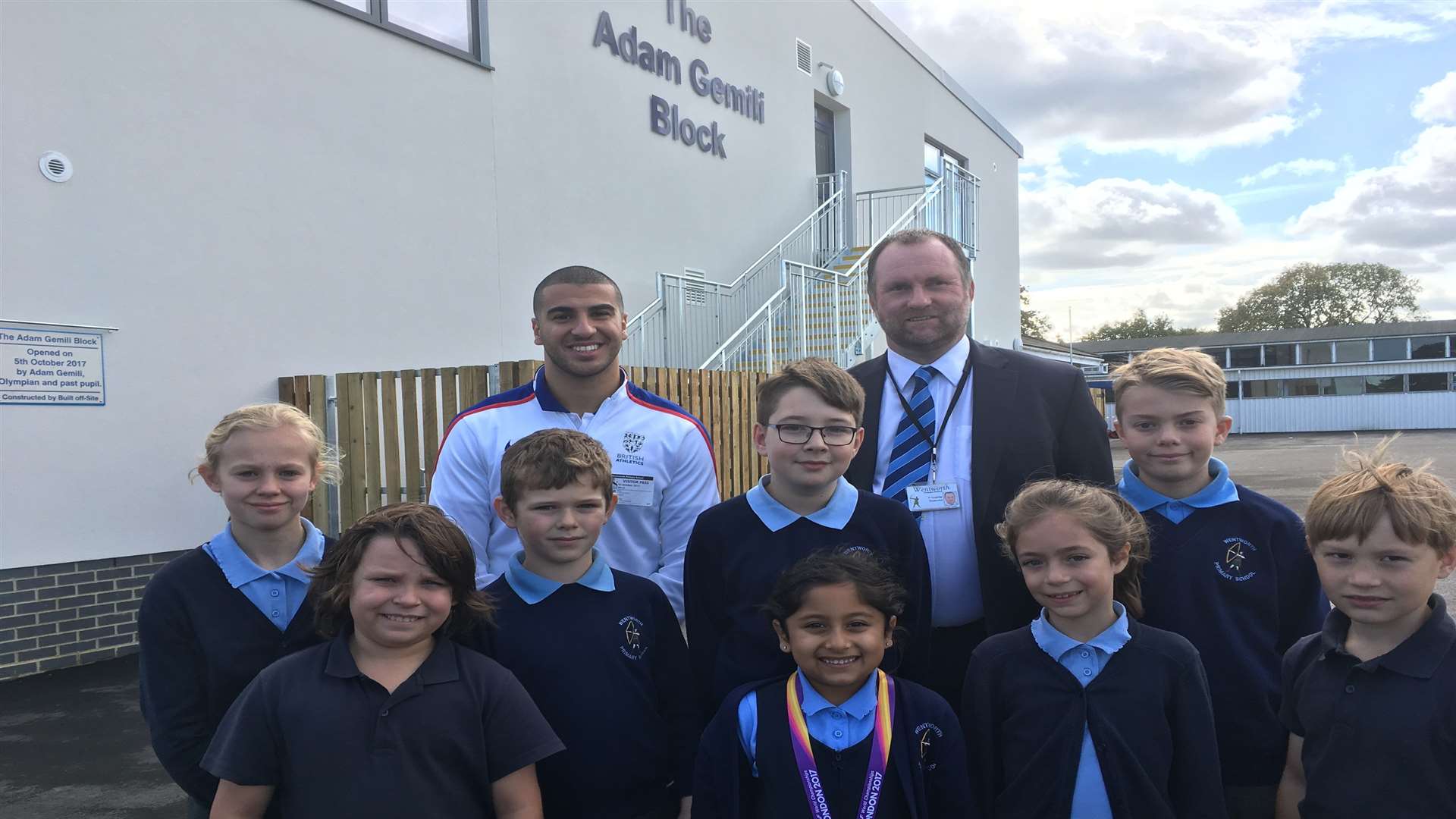 Sprinter Adam Gemili is welcomed by headteacher Paul Langridge and pupils at his old school