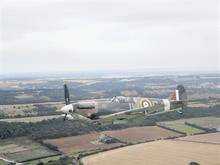 An iconic WWII aircraft flies just metres from one of Action Stations' chartered helicopters