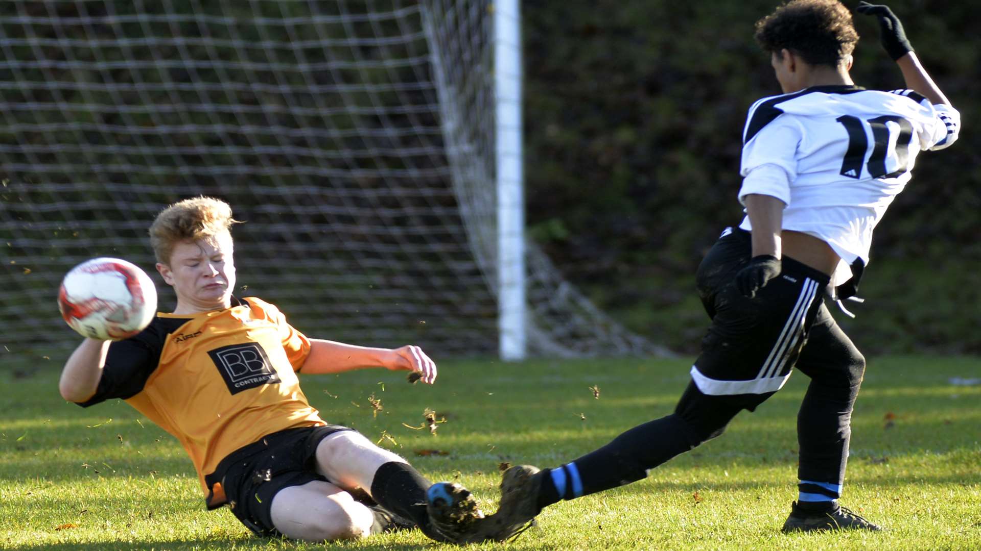 Pegasus 81 under-16s (yellow) slide in against Real 60 Picture: Ruth Cuerden