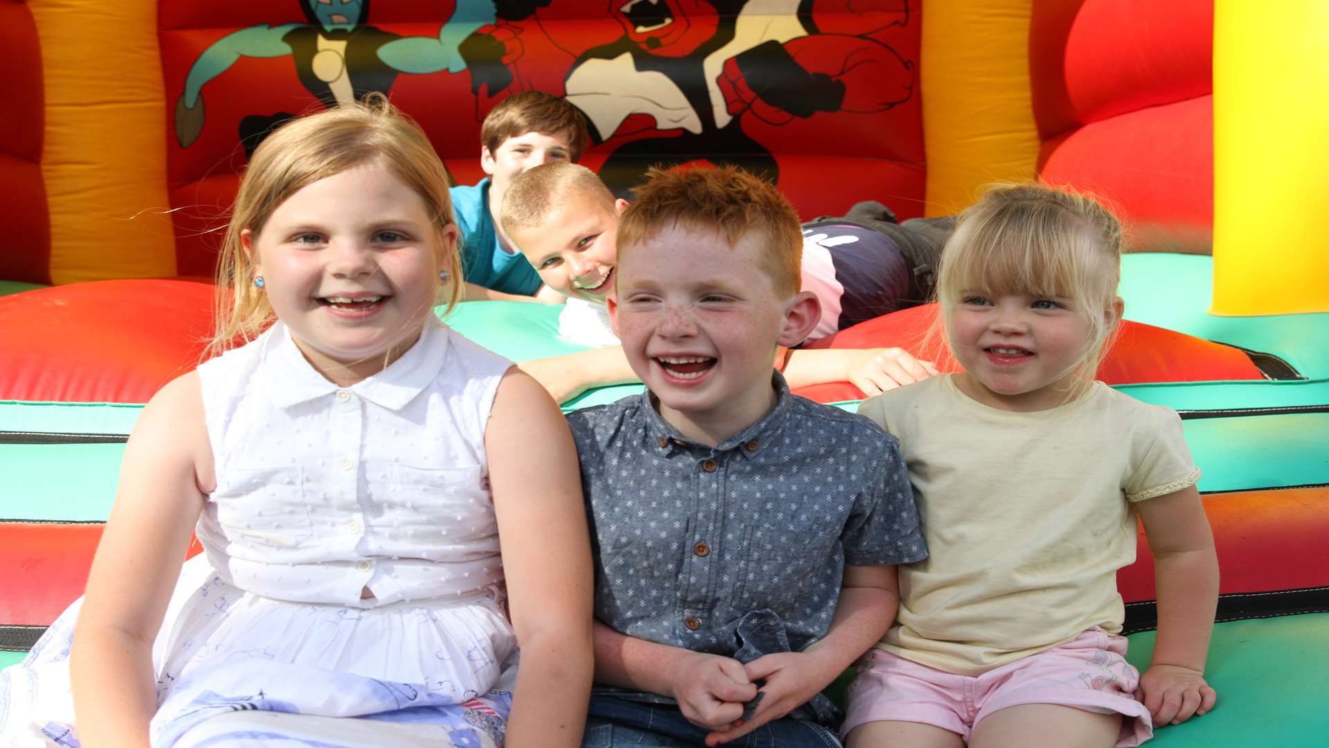 Lauren Hadlow, eight, Killian Murphy, six, and Maisie Sparks, three, have fun on the bouncy castle