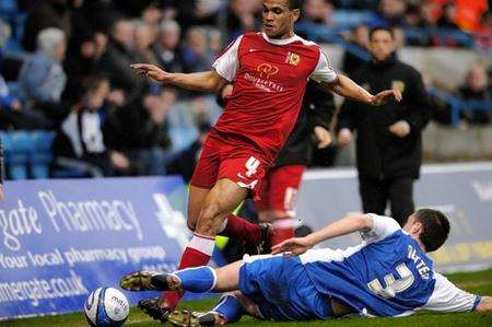 John Nutter challenges MK Dons midfielder Mathias Doumbe