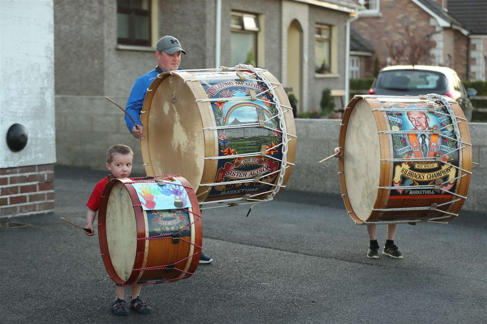 Mark Black and his sons Thomas, left, and Adam play Lambeg drums outside their home (Niall Carson/PA)