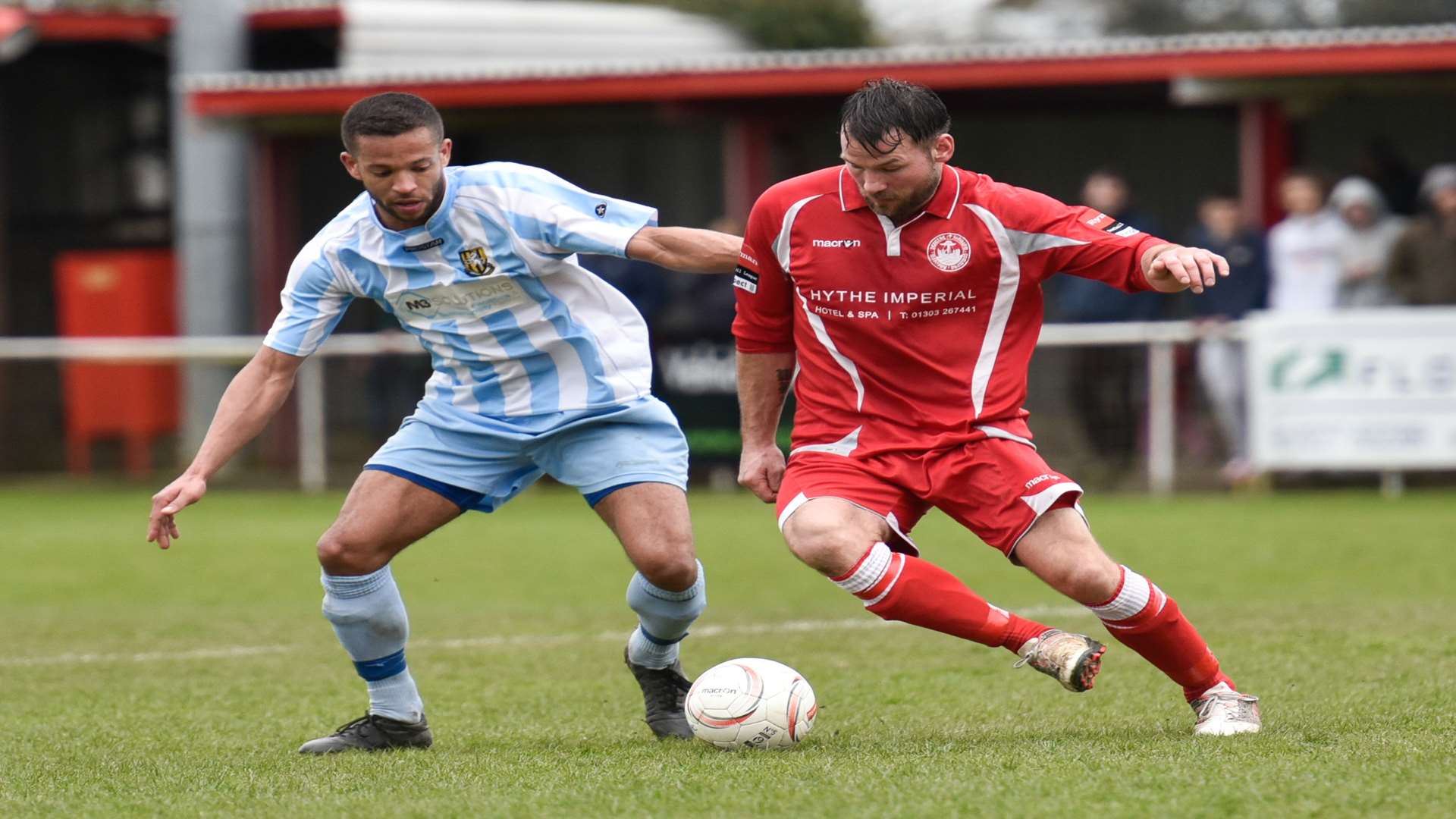 Hythe striker Craig Thompson tries to get away from Folkestone's Nat Blanks during the local derby at Reachfields on Easter Monday Picture: Alan Langley