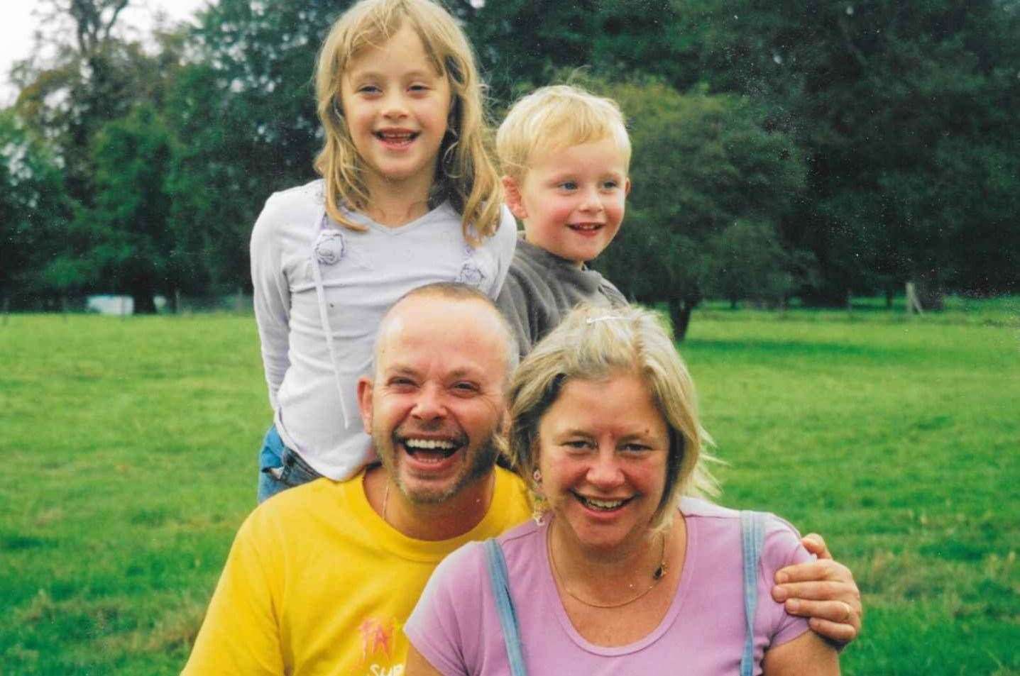 A family photo of Jeremy and sister Jess behind their mum and dad, Clare and Giles