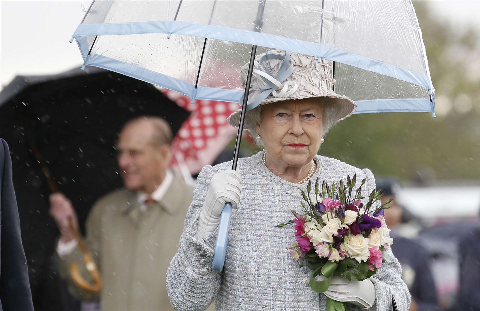 The Queen, under her umbrella, has two birthdays because of the British weather (Suzanne Plunkett/PA)