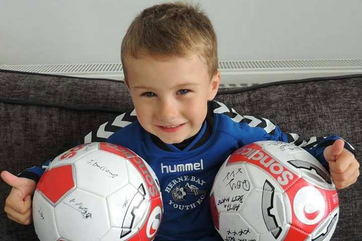 Connor with his Herne Bay Youth FC shirt and signed footballs