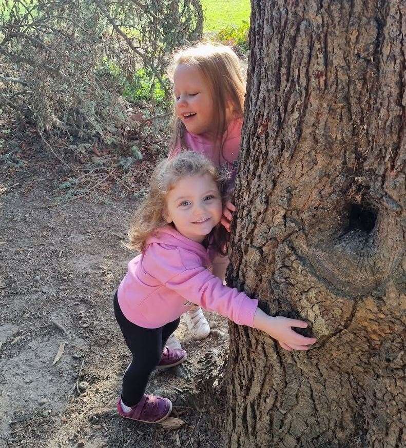 Olivia laughs as sister Imogen hugs a tree. Picture supplied by ellenor