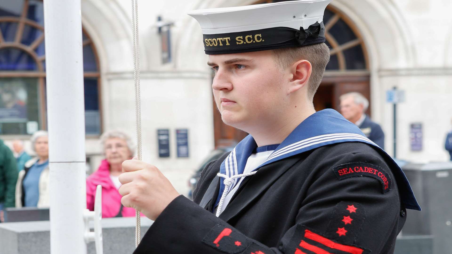 Able Cadet Matthew Sheppard raises the flag