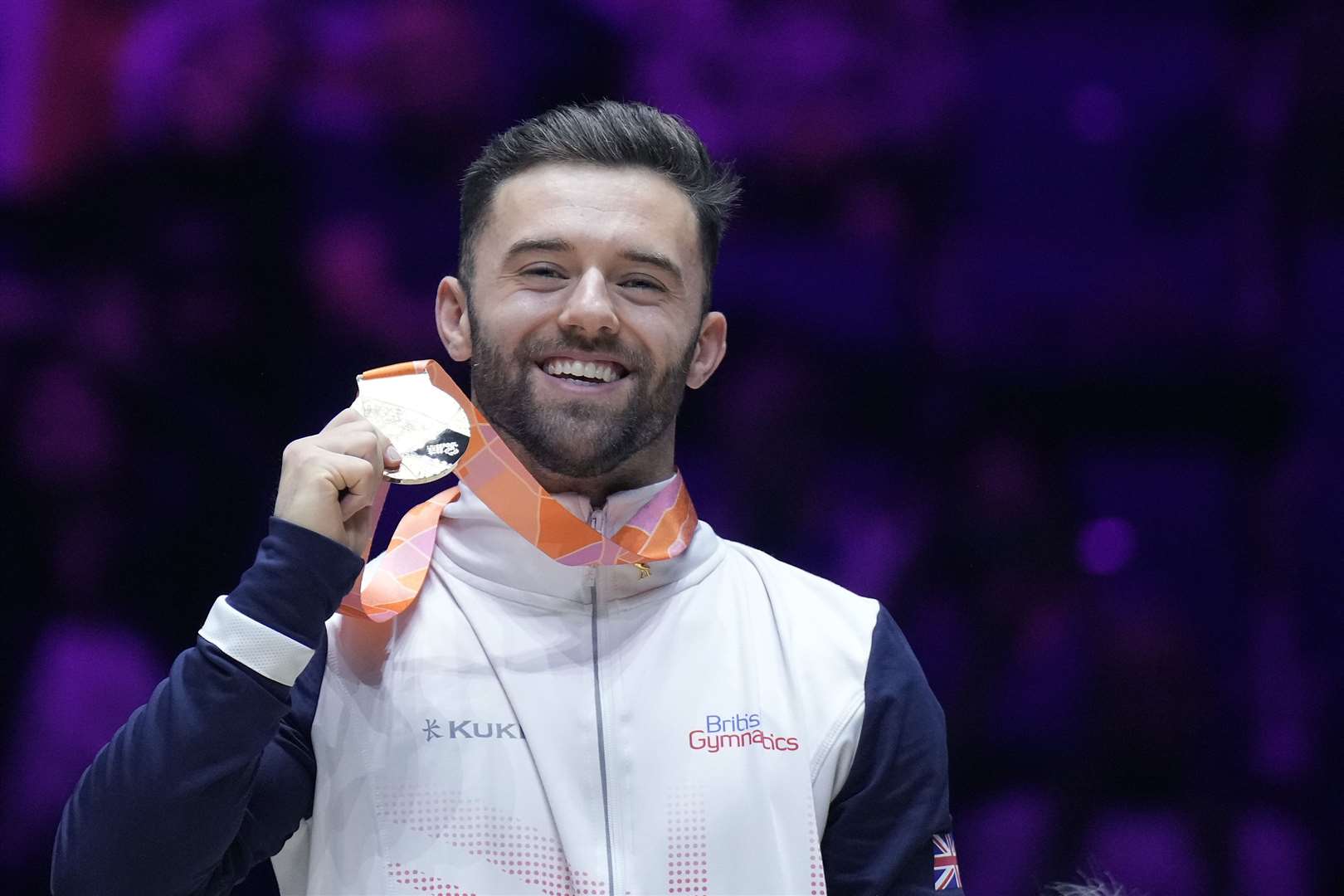 Giarnni Regini-Moran beams after winning men’s floor gold at the World Gymnastics Championships. Picture: British Gymnastics/Simone Ferraro