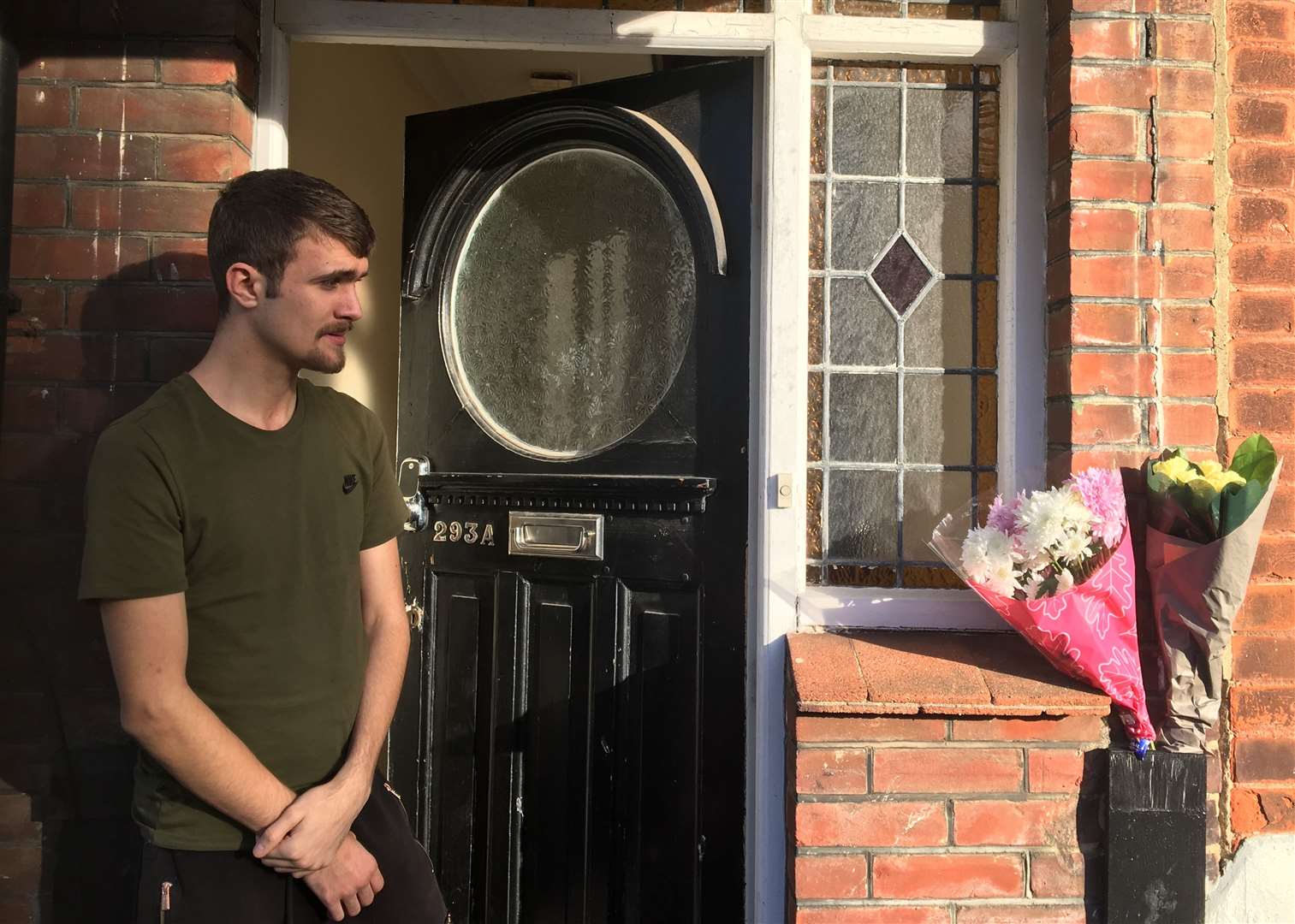 Alfie Mitchell next to flowers left for Mr Wright