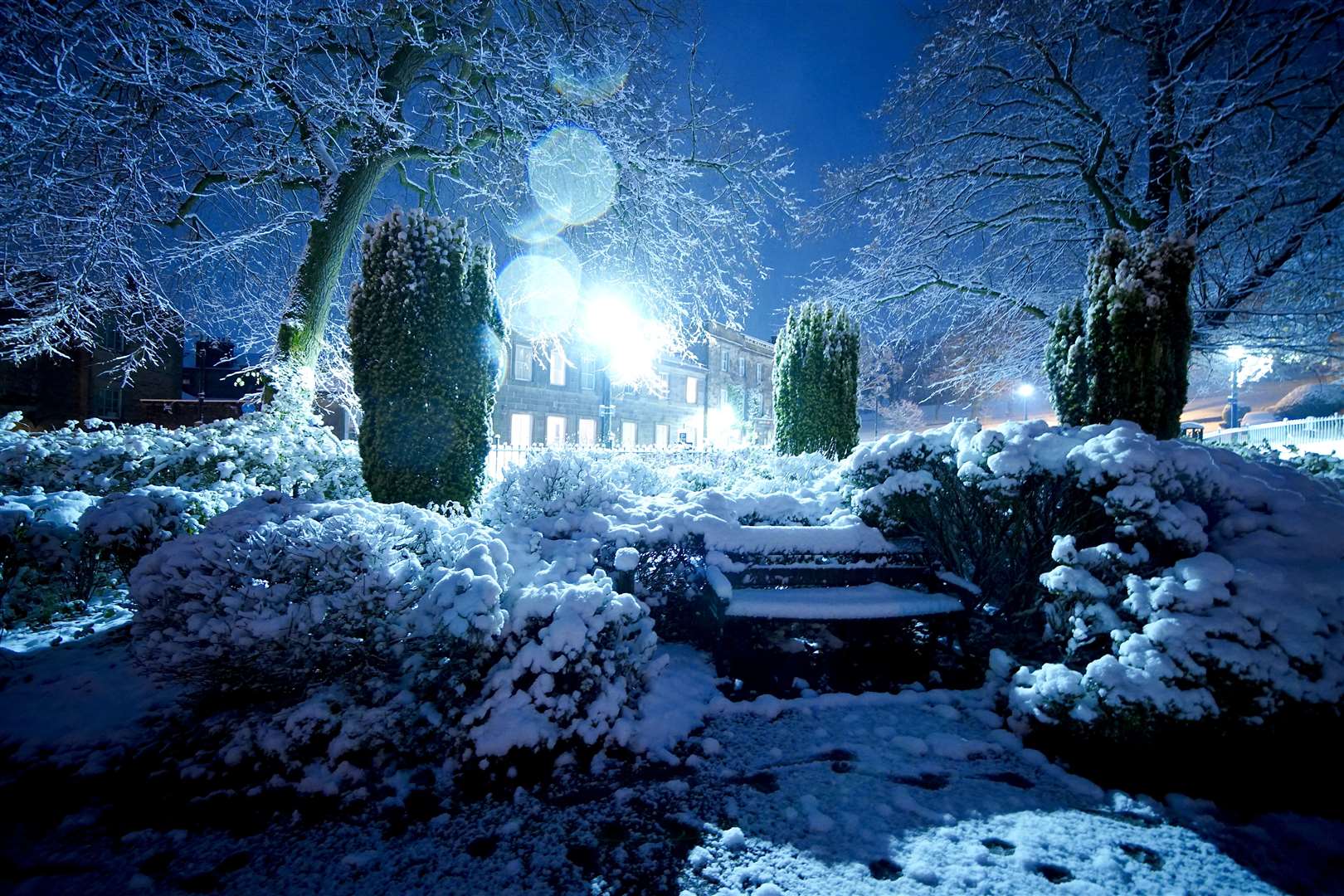 Overnight snow covers foliage and benches in a park in the centre of Buxton (Peter Byrne/PA)