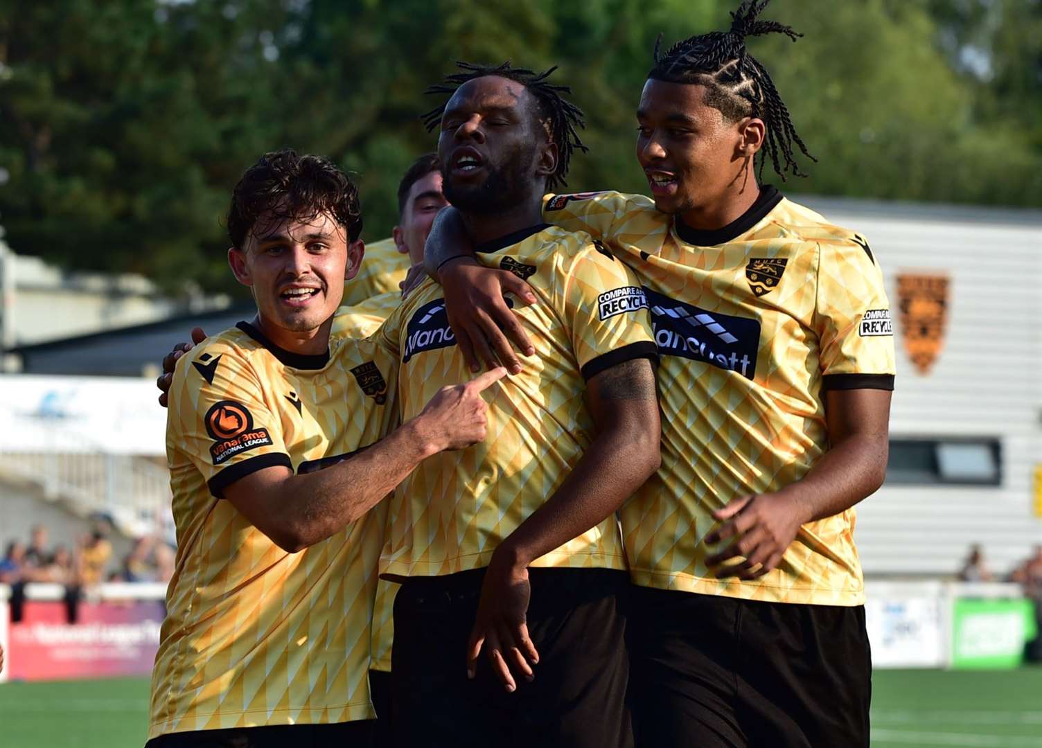 Shaq Coulthirst, centre, celebrates with Jon Benton and Tayt Trusty after giving Maidstone a 2-1 lead against Chesham. Picture: Steve Terrell