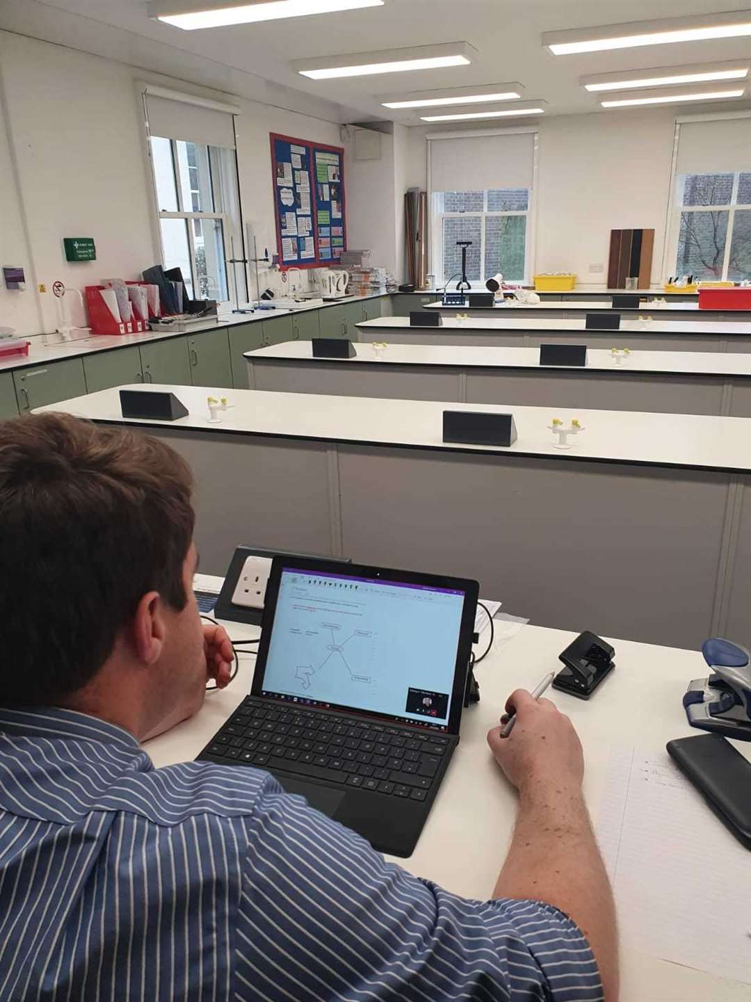 Teacher Richard Stewart delivers a science lesson to an empty classroom - all his pupils are on line