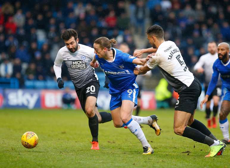 Gills striker Tom Eaves being held back Picture: Andy Jones