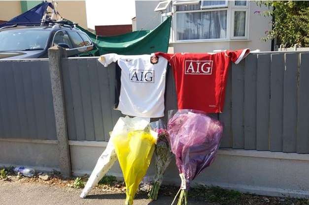 Football shirts and floral tributes were left outside a house