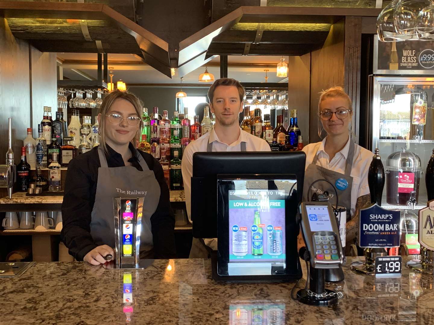 The bar staff are ready to meet their new customers at The Railway in Station Road, Rainham (18008990)