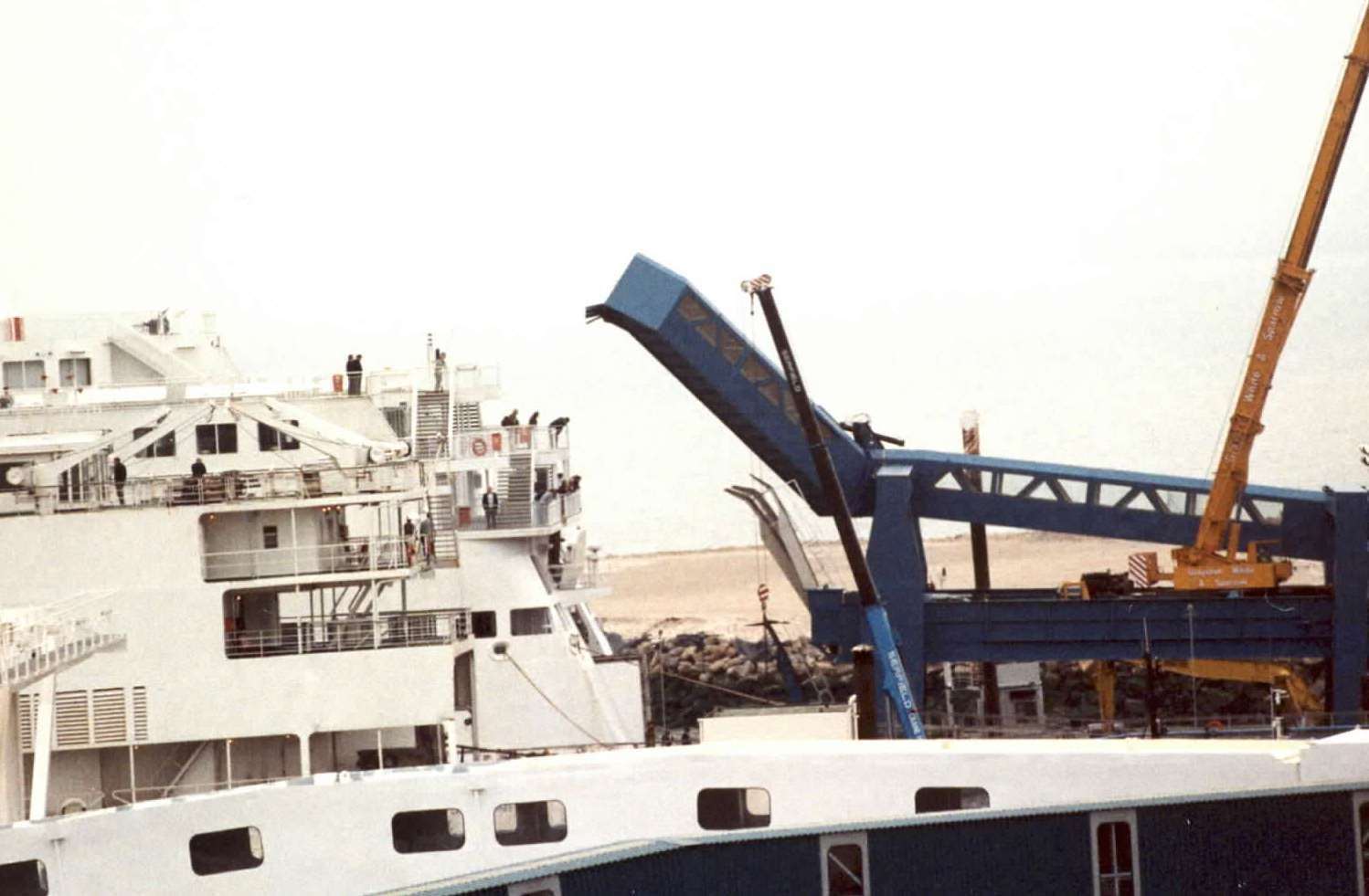 A crane winches up the collapsed walkway following the disaster