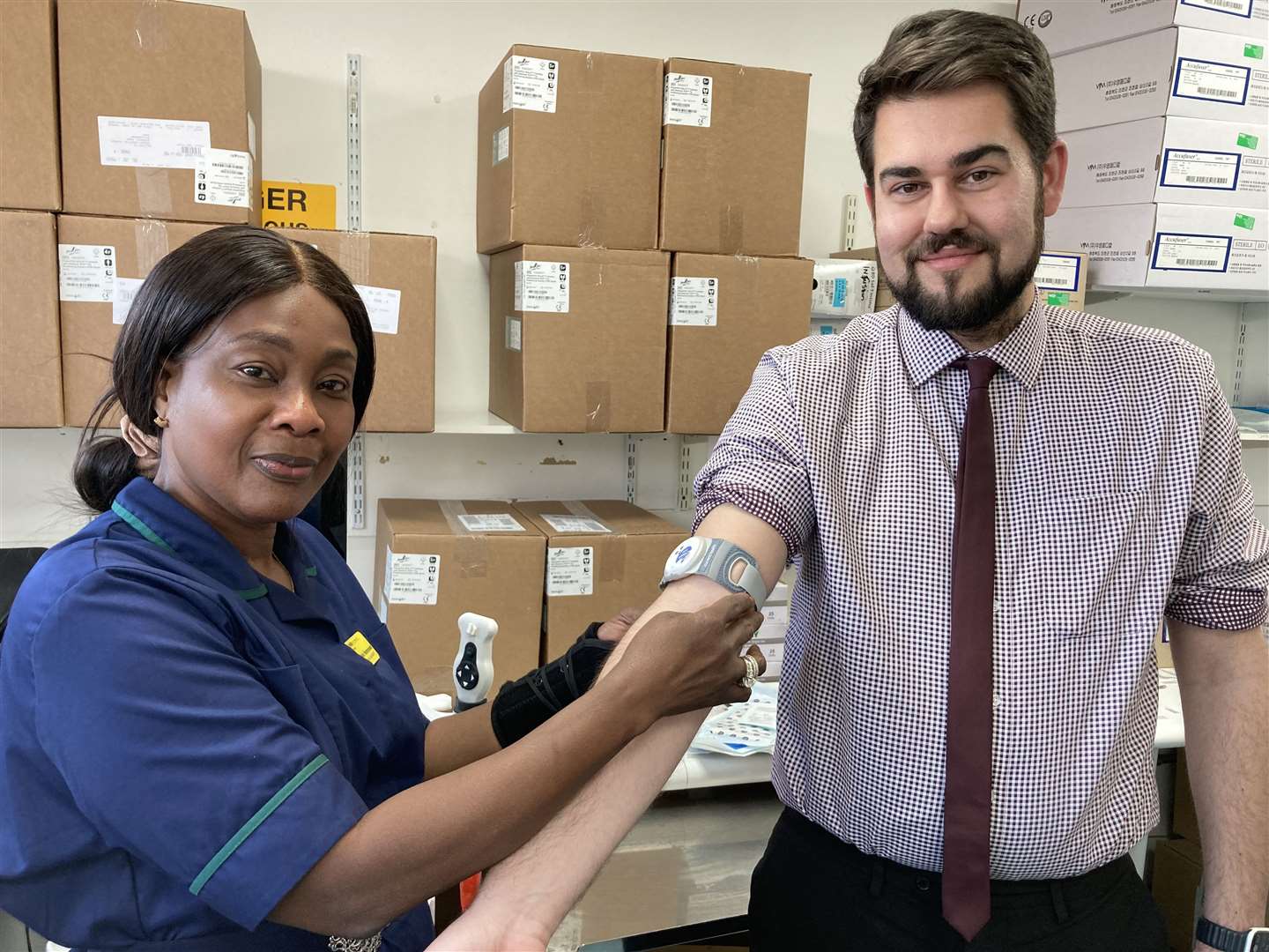 Medway Maritime Hospital's Smart team leader Jackie Hammond, who is behind the virtual wards project, demonstrates the 'wearable' on Will Chambers