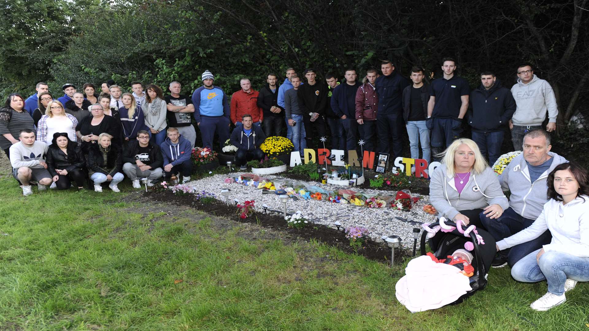 Loved ones of Adrian Stroud gather at the roadside memorial