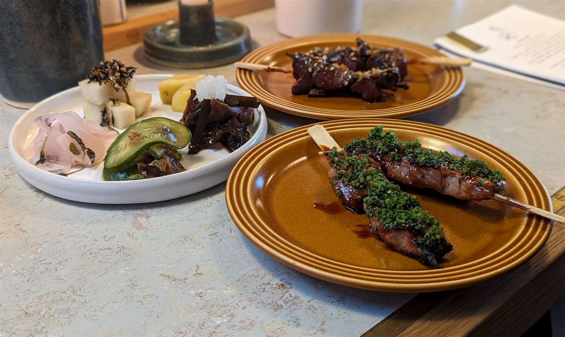 Skewers of lamb hearts and pork collar served alongside pickles and ferments