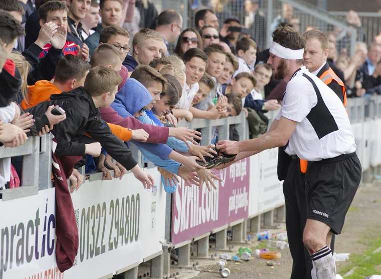 Rory McAuley hands his boots to a young Dartford supporter Picture: Andy Payton