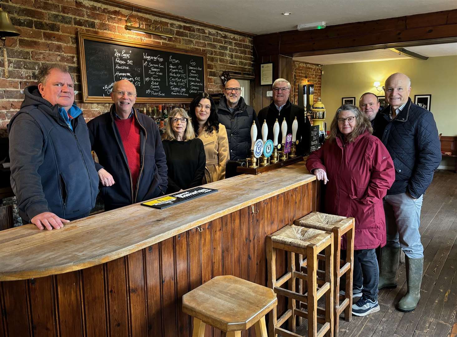 The steering committee: behind the bar, from left, Warren Gilbert, Jonathan Pearce, Kim Mitchell, Kerry Goodfellow, Graham Bonner-Leney, and Alan Ritchie. In front of the bar, from left, Sarah Talbutt, Robert Merrifield and Michael Wooldridge